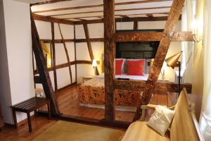 Un dormitorio con una gran cama de madera con almohadas rojas en Hotel de Charme 'zum Schiff' en Iffezheim