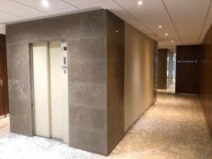 a hallway in a building with a large stone wall at Appartement Hyper centre avec garage in Saint-Étienne