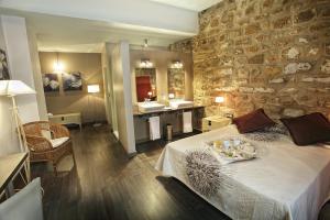 a bedroom with a large bed and a stone wall at Alvaro de Torres Boutique in Úbeda