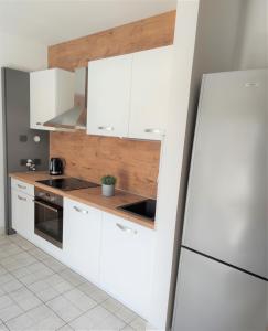a kitchen with white cabinets and a refrigerator at Apartments Riba in Vis