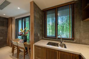 a kitchen with a sink and a table with chairs at Ponte Boutique Da Nang in Danang +74 photos