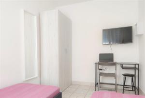 a bedroom with a desk and a tv on a wall at Apartments Riba in Vis