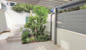 a fence with a palm tree in a courtyard at Apartments Riba in Vis