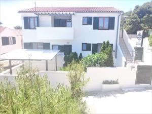 a white house with plants in front of it at Apartments Riba in Vis