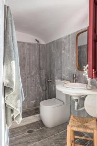 une salle de bain avec toilettes et lavabo dans l'établissement Parathira cave houses oia by cycladica, à Oia