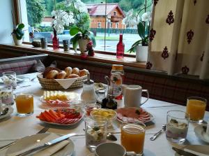 einen Tisch mit Frühstückszutaten auf einem Tisch mit Fenster in der Unterkunft Pension Andrea in Fusch an der Glocknerstraße