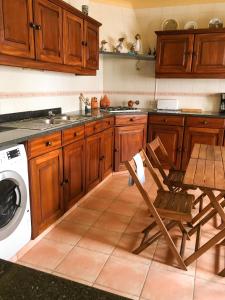 a kitchen with a washing machine and a chair at Carrapateira Lodge in Carrapateira