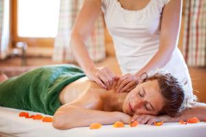 a woman getting a massage from a man at Hotel Konradshof in Seewald