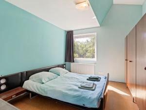 1 dormitorio con cama con sábanas azules y ventana en Sun kissed Villa in Kobbegem with Private Garden 