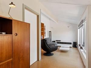 a living room with a black leather chair at Sun kissed Villa in Kobbegem with Private Garden 