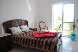 Un dormitorio con una cama con una bata roja. en Marine Freestyler Glorious Terrace en Faro