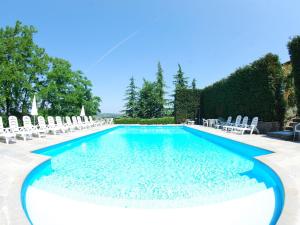ニッツァ・モンフェッラートにあるFabulous Mansion in Nizza Monferrato with Swimming Poolの芝生の椅子と椅子付きのスイミングプール