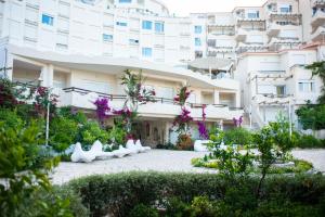 a building with white sculptures in front of it at Apartment bay, Bougainville Bay Resort in Sarandë