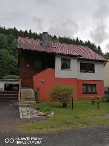 a red and white house with a red roof at Fewo am Fuße der Bergbahn in Mellenbach-Glasbach