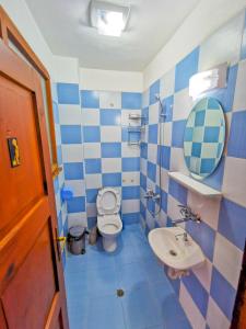a blue and white bathroom with a toilet and a sink at Guest House Dorkos in Dorkovo