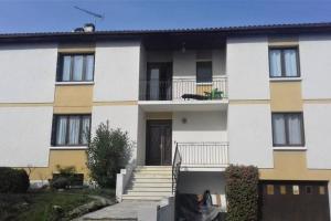 a building with stairs and a dog sitting on a balcony at Spacieux appartement proche centre et piscine in Condom
