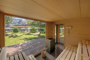 a screened in porch with a view of a yard at ADLER HÄUSERN Gourmet & Spa Hotel in Häusern