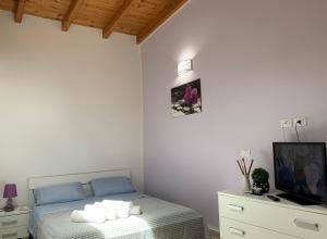 ウッジャーノ・ラ・キエーザにあるMasseria Capeceの白いベッドルーム(ベッド1台、テレビ付)