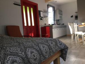 a room with a bed and a kitchen with a red door at Marzeniec w Beskidzie Niskim in Wapienne
