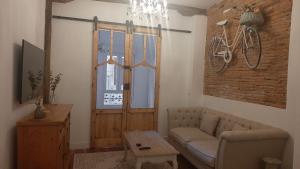 a living room with a couch and a bike on the wall at Apartament El Patio del Museo in Bilbao