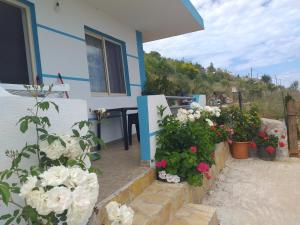 a house with flowers in front of it at Grand Seaview Apartments in Ksamil