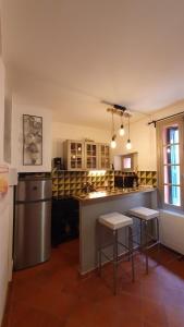 a kitchen with two bar stools and a counter top at Au coeur de Collioure in Collioure +6 photos