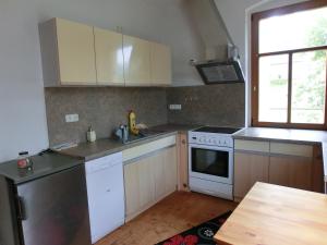 eine kleine Küche mit weißen Geräten und einem Fenster in der Unterkunft FeWo zwischen Augustusburg und Freiberg in Eppendorf
