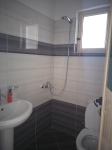 a bathroom with a shower and a toilet and a sink at Grand Seaview Apartments in Ksamil +37 photos
