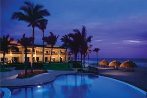 a resort with a swimming pool in front of the ocean at Luxury Suites By Estrella del Mar in Mazatlán