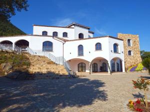 a large white building with stairs in front of it at Tenuta Su Vrau in Posada