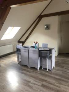 - une salle à manger mansardée avec une table et des chaises dans l'établissement Calme & Accueillant, à Grandfresnoy