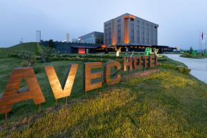 a large sign in the grass in front of a building at Avec Hotel in Canakkale