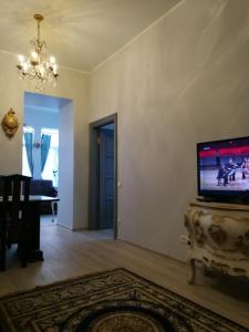 een woonkamer met een flatscreen-tv op een tafel bij Golden Amber Apartment in Liepāja