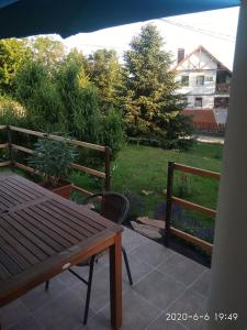 a patio with a wooden table and two benches at BalatUniversum Apartmanhouse in Révfülöp