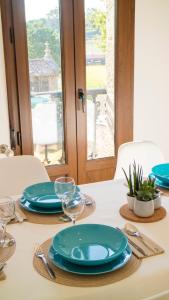 a white table with blue plates and silverware on it at Apartamentos Casa Cabana in Cambados