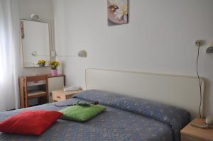 ein Schlafzimmer mit einem Bett mit zwei Kissen darauf in der Unterkunft Hotel Roxy Floridiana in Rimini