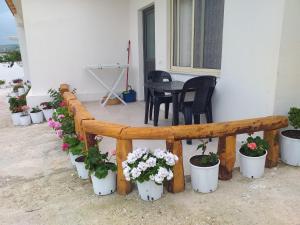a wooden bench with potted plants on a patio at Grand Seaview Apartments in Ksamil