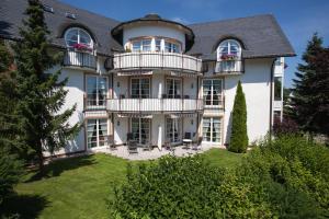 a large white house with a balcony at Villa Katharina Ferienwohnungen in Willingen