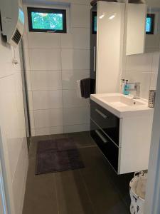 een witte badkamer met een wastafel en een spiegel bij Vakantiehuisje Time Out in Zelhem +22 foto's