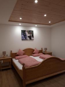 een slaapkamer met een groot houten bed met rode kussens bij Unterhohnenhof in Triberg