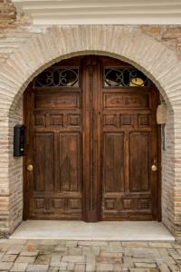 un ingresso a un edificio con porta in legno di Plaza Apartamentos a Binéfar