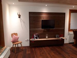 ein Wohnzimmer mit einem Flachbild-TV an der Wand in der Unterkunft Unterhohnenhof in Triberg