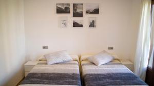 カンバードスにあるApartamentos Casa Cabanaのベッドが2つあり、壁に絵が飾られている寝室 +89枚の写真