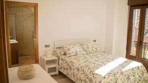 un dormitorio con una cama y una mesa en Apartamentos Casa Cabana, en Cambados