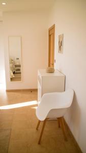 a white chair in a room with a mirror at Apartamentos Casa Cabana in Cambados