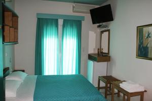 a bedroom with a green bed and a television at Andreas in Ammoudia