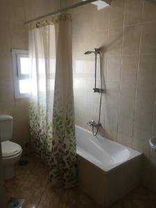 ein Badezimmer mit einer Badewanne, einem WC und einem Duschvorhang in der Unterkunft Luxury Villa Panorama Beach in El-Alamein