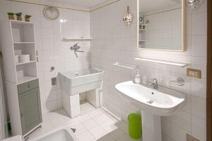 a white bathroom with a sink and a toilet at Casa Regina in Salò +43 photos