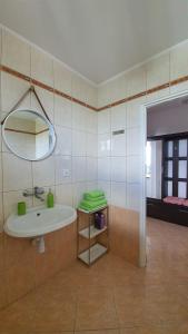 ein Bad mit einem Waschbecken und einem Spiegel in der Unterkunft Apartament Jeleń in Hajnówka