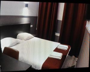 sypialnia z łóżkiem z biurkiem i stołem z ręcznikami w obiekcie Hotel Manofa w Amsterdamie